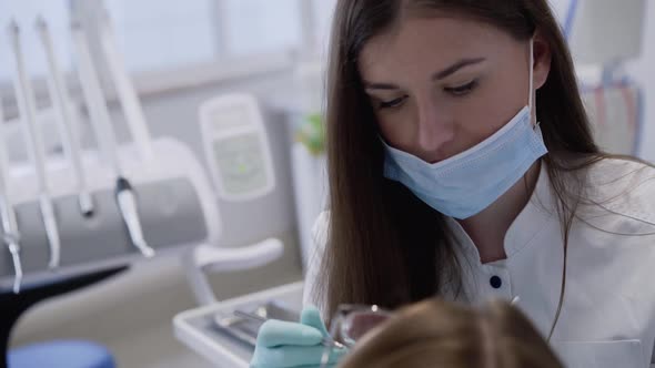 Female Dentist in Gloves Consulting and Using Tools for Working with Patient alt