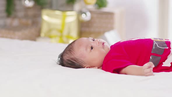 Cute Newborn baby wearing santa costume lying and moving hand and body alt