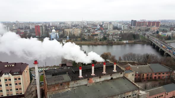 Smoke from chimneys forms clouds. Large clouds over the city from pipes of thermal power plant  