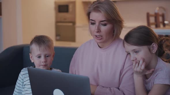 Woman and Her Kids Using Laptop at Home
