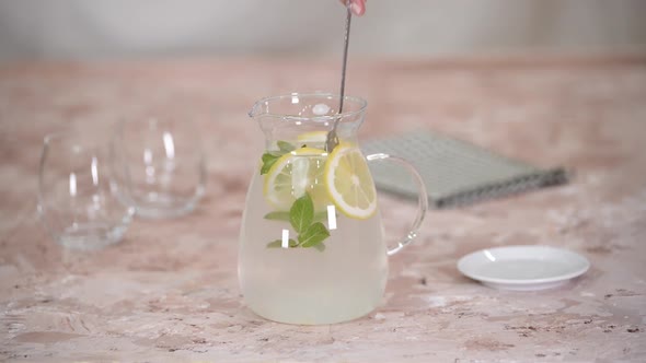 Female Hands Stirring a Lemonade with Spoon