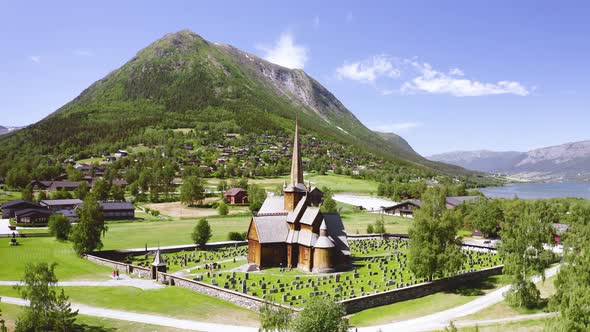 Old And Historic Stave Church Offering Mountain Views On A Sunny Day At Lom In Innlandet, Norway. - alt