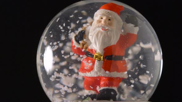 Santa Claus in Snow Globe on Black Background