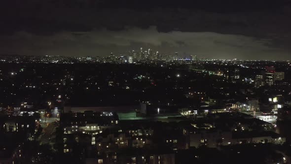 AERIAL: Over Dark Hollywood Los Angeles at Night with Clouds Over Downtown and City Lights  alt
