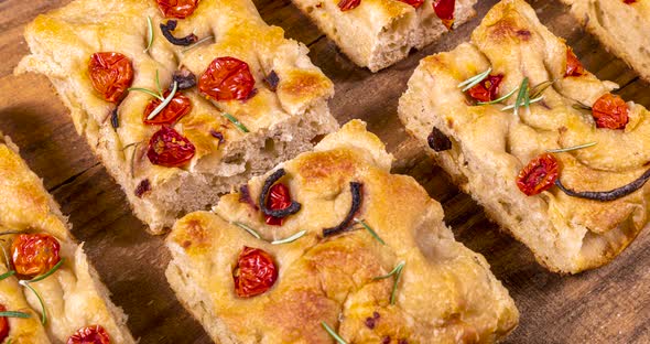 Homemade italian flat bread - Focaccia contorta. With olives, olive oil, rosemary, tomatoes. Traditi alt