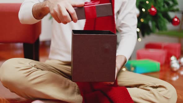 Surprise Asian men open the gift box in the living room at home.