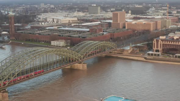 AERIAL: Over Cologne Old Town and View on Rhine and Hohenzollern Bridge with Train Crossing and Boat alt