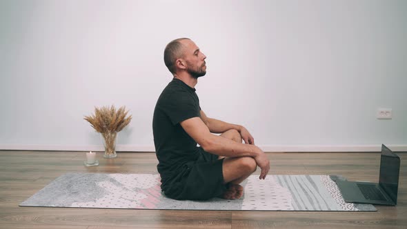 Caucasian Man Does Yoga Online Man Sits in the Lotus Position and Does Breathing Exercises Yoga for