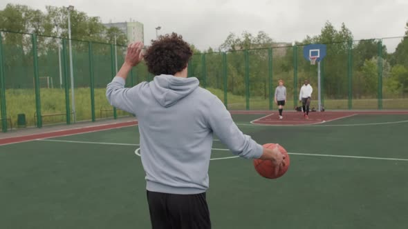 Guys Meeting on Outdoor Basketball Court to Shoot Hoops alt