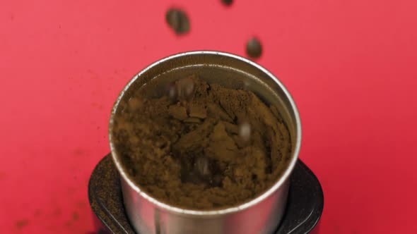 Coffee Beans Grind in Electric Mill Into Powder, Red Background. Morning Concept alt