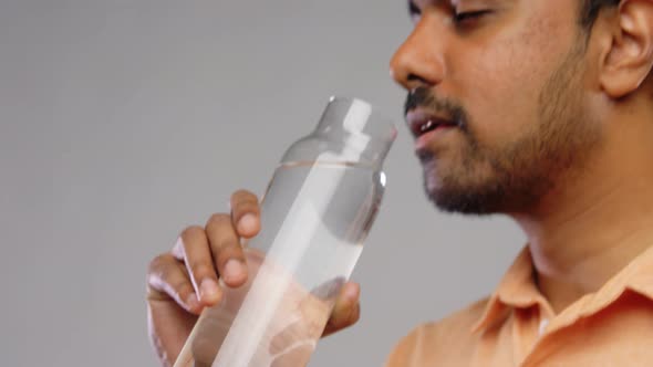 Happy Indian Man Drinking Water From Glass Bottle alt