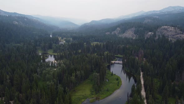 Reveal drone shot of kayakers on the winding Payette River in the Idaho forest. This cinematic 4K wi alt