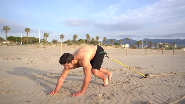 shirtless athlete preparing to perform resistance exercise with weight alt