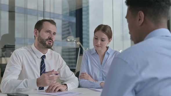 Rear Back View of Guy Talking To Business People in Office  alt