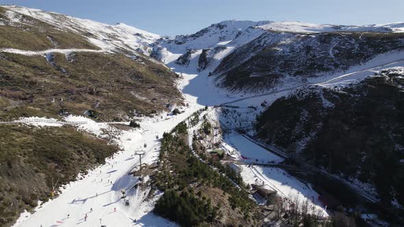 Skiers on slope and cableway, Sierra Nevada in Spain. Aerial circling