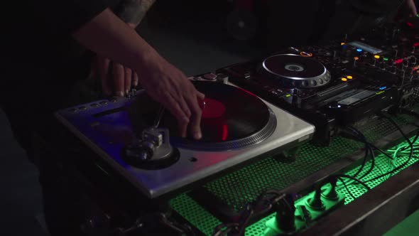 Professional African American Dj Mixing Track Using Vintage Vinyl Record Turntable in Nightclub alt