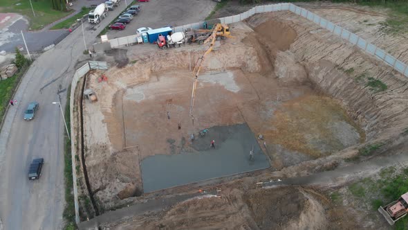 Aerial view construction workers pouring concrete at construction site basis. alt