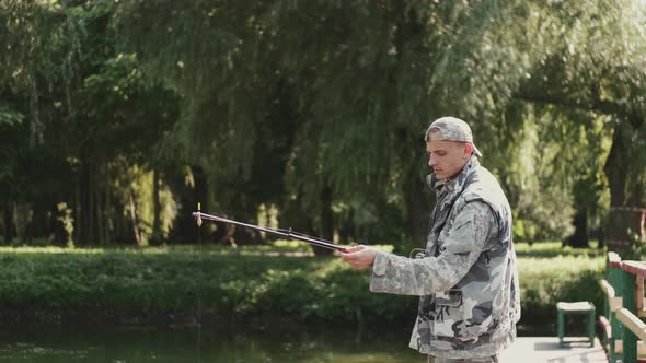 Confident Fisherman Preparing a Rod for Fishing at the Pond alt