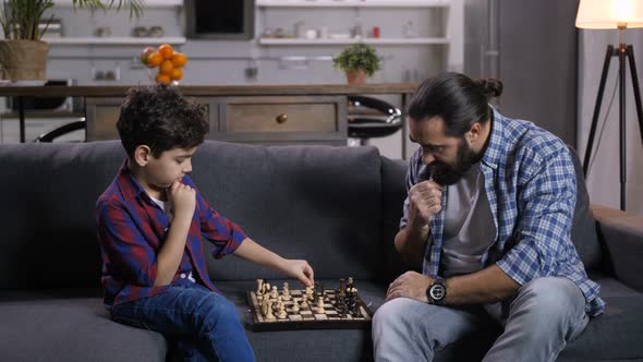 Clever Son Moving Knight Piece During Chess Game alt