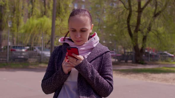 Close Up of Young Woman with Mobile Phone on Street in Sunny Weather alt