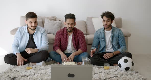 Three Indian Young Men Watching Football at Home alt