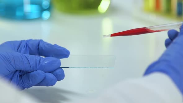 Epidemiologist Dripping Blood Sample on Glass, Analyzing Biomaterial, Virus alt