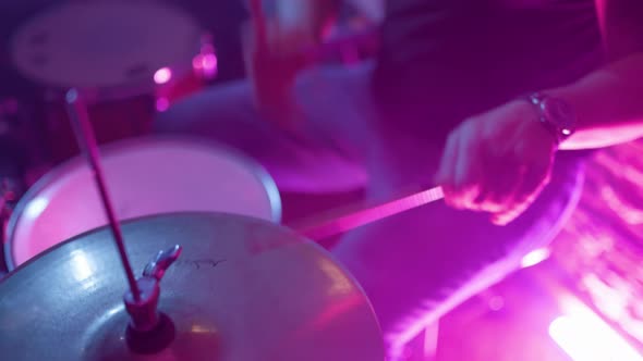 Young musician faceless drummer playing drums with drumsticks alt