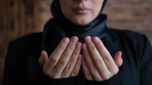 Young Muslim Woman in Hijab Raises Her Hand and Prays