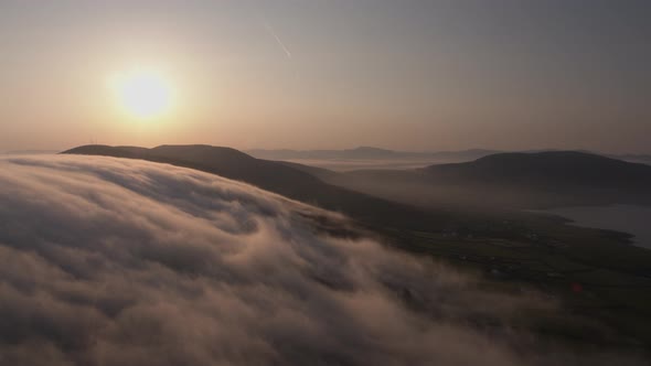 Early morning clouds drift over the mountains in Co Kerry Ireland as the sun shines during the summe alt