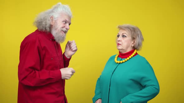 Cheerful Funny Senior Man Dancing As Shocked Woman Standing with Dazed Facial Expression Holding alt