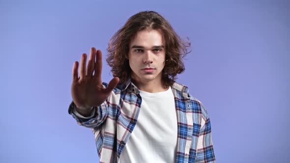 Portrait of Serious Man Showing Rejecting Gesture By Stop Palm Hand Sign alt