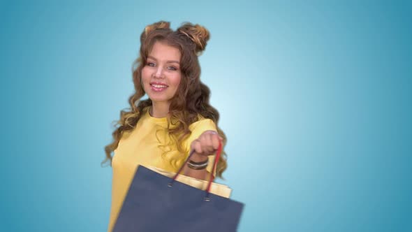 Attractive Young Girl is Spinning Around Herself Holding Shopping Bags alt