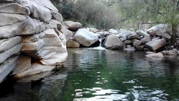 Flying Over Clear River with Rocks in the Mountain. alt