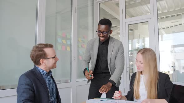 Ethnic Diverse Team Brainstorming in Office Discussing Startup Project