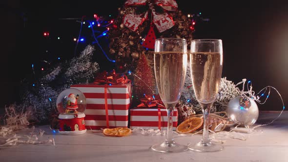 Glasses with alcoholic beverages stand against the background of New Year's gifts, 