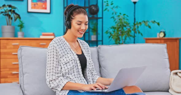 The Crazy Teenager Spends After School Time on the Couch Sitting with Laptop on Lap alt