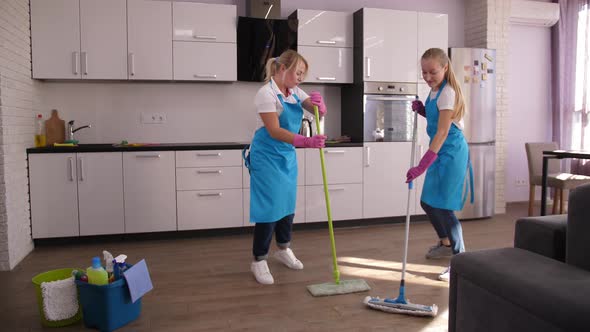 Happy Cleaning Ladies Dancing While Mopping Floor alt