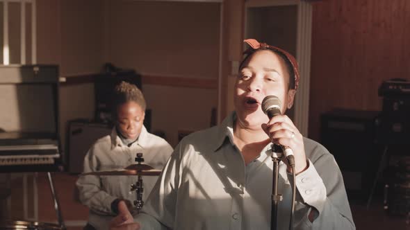Woman Singing in Microphone at Music Studio alt