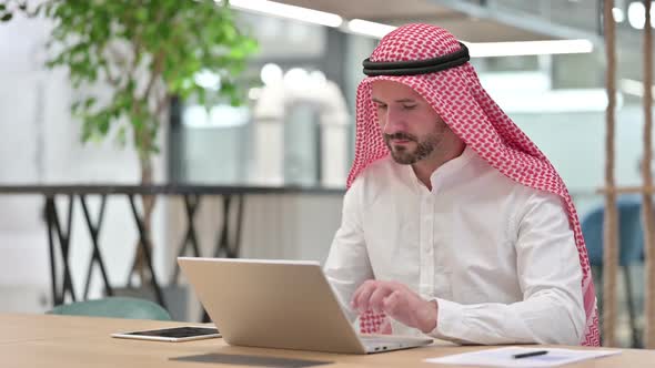 Serious Arab Businessman with Laptop Looking at Camera alt