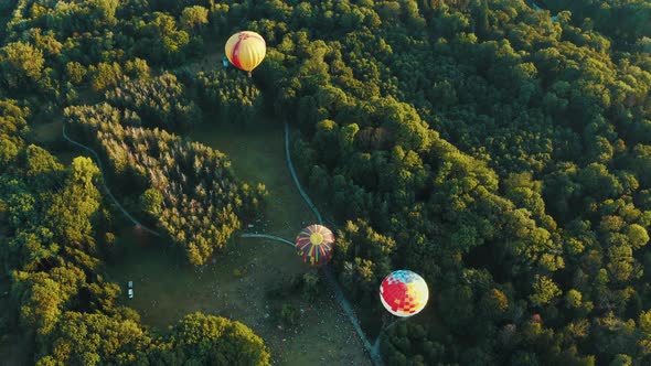 Aerial View of Three Hot Air Balloons Takes Off Among the Trees in the Park. Beautiful Sky and alt