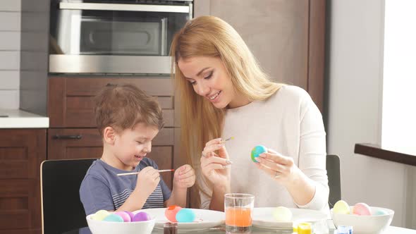 Young Woman with Her Adorable Little Son Making Handmade Decorations for Easter Holiday