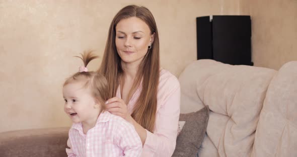 Young Beautiful Woman Holding Little Child on Her Knees