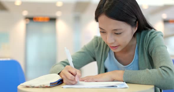 Student writing on her note at school  alt