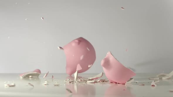 Pink pig money box falls on a table and breaks on a pieces