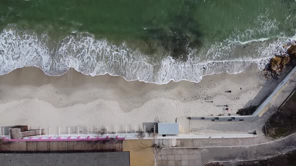 Top aerial view on the beach on sunny day. Aerial view waves break on white sand beach.
