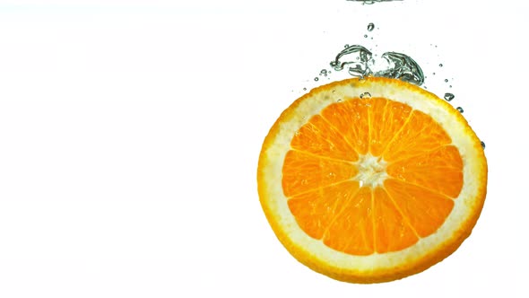 Super Slow Motion Shot of Falling Orange Slice Into Water at 1000Fps alt