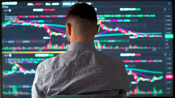 Stock Market Broker Analyzing Data and Graphs on Multiple Computer Monitors alt