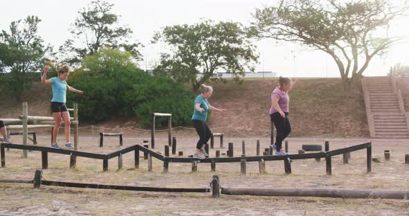 Female friends enjoying exercising at boot camp together alt