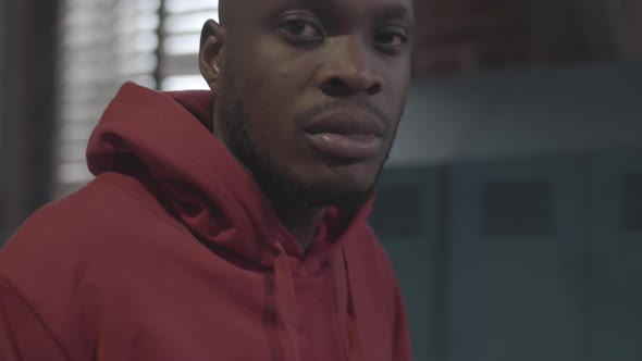 Young Black Boxer Taking off Hood and Staring at Camera alt