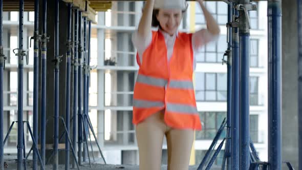 Female architect having fun dancing at construction siteof an under-construction building alt